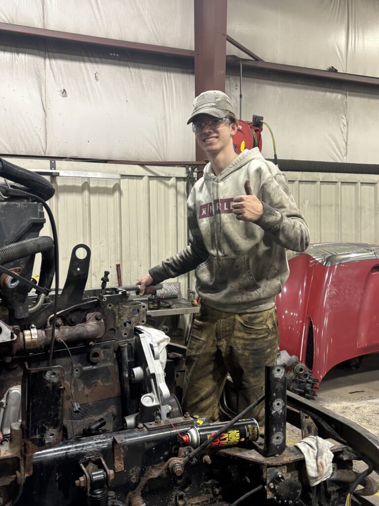student working on a vehicle engine